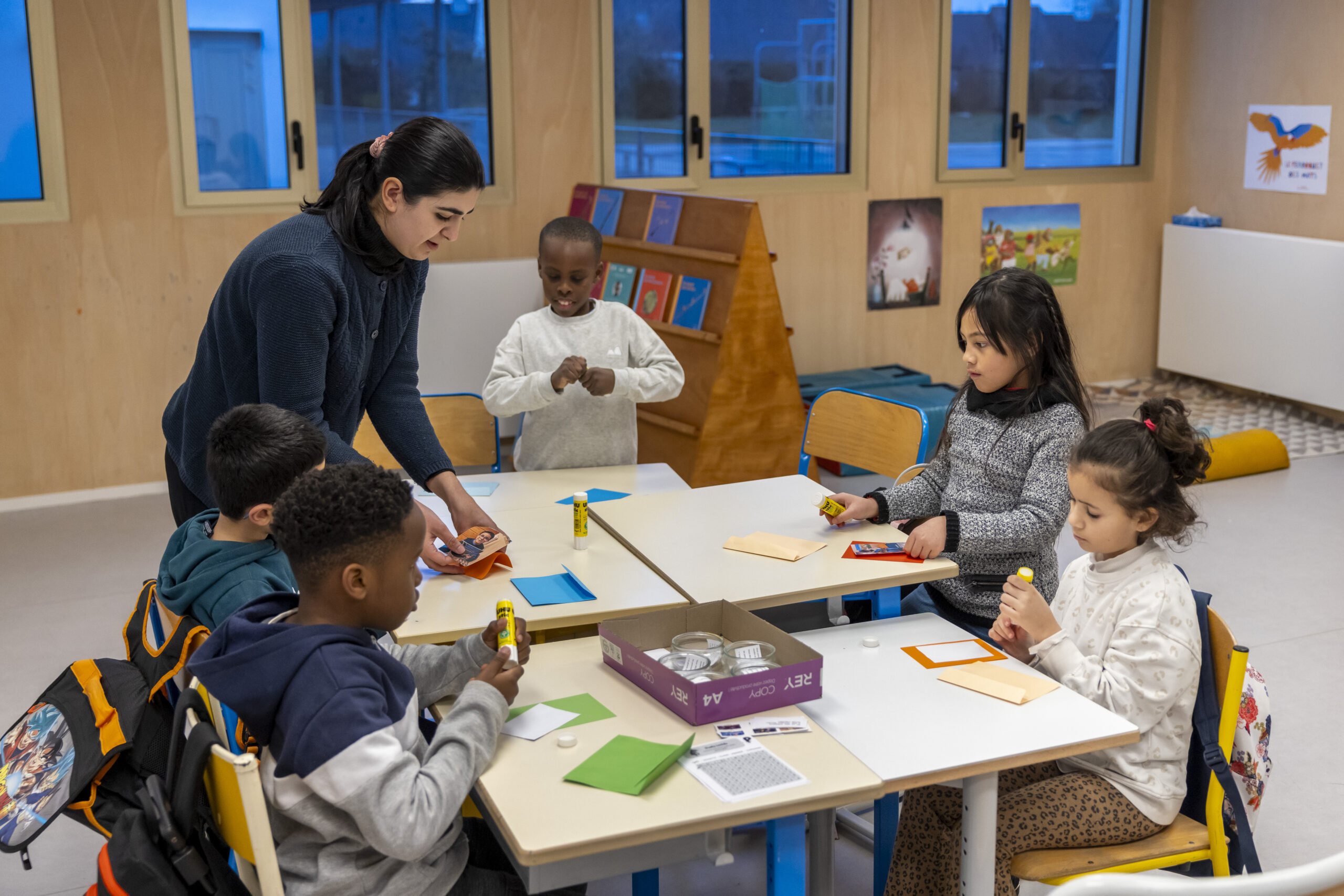 Atelier des clubs Lecture à l’école René Guy Cadou Image d'illustration d'enfants à l'école qui écrivent sur leur cahier